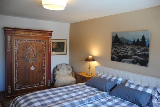 Schlafzimmer mit Doppelbett und bemaltem Bauernschrank
