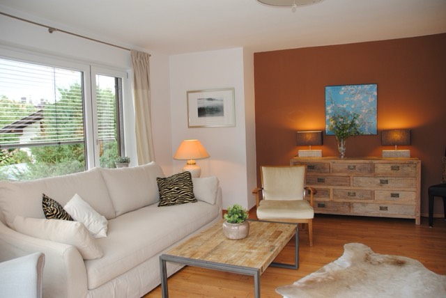 Wohnzimmer mit Kommode und warmer Terrakotta-Wand